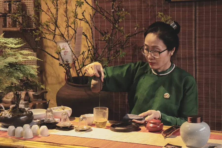 Participants enjoying a Vietnamese tea and calligraphy mindfulness workshop during a Vietnam spiritual & mindful journey