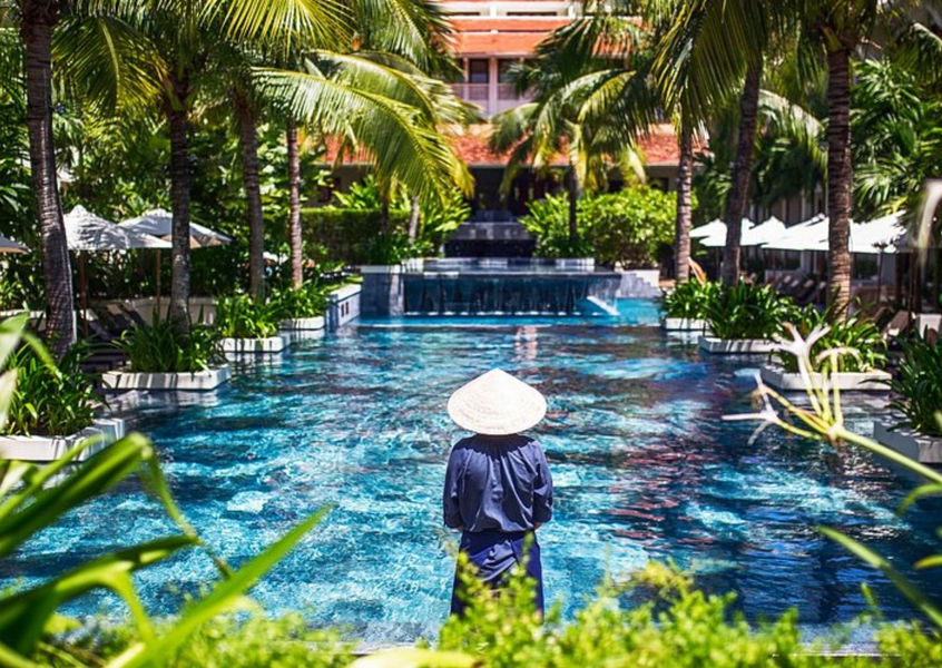 Vietnamese staff by Almanity Hoi An resort pool and palms