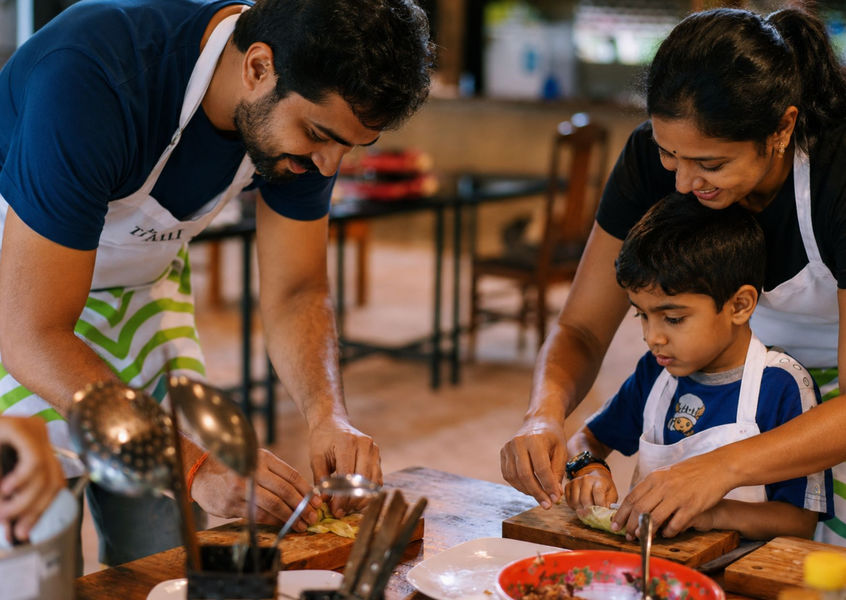 Family with a child preparing fresh ingredients together during a Vietnamese cooking class