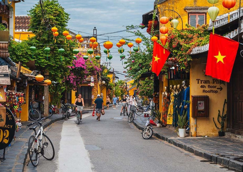 Colorful lantern-lined street in Hoi An Ancient Town with bicycles parked along the road
