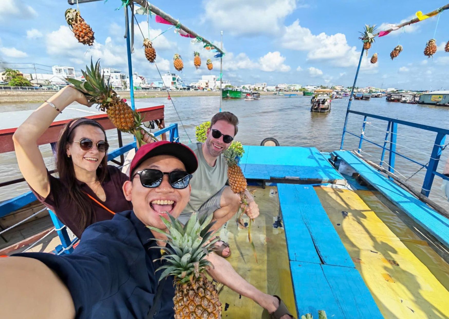 Tourists riding traditional wooden boats along a palm-lined canal in the Mekong Delta