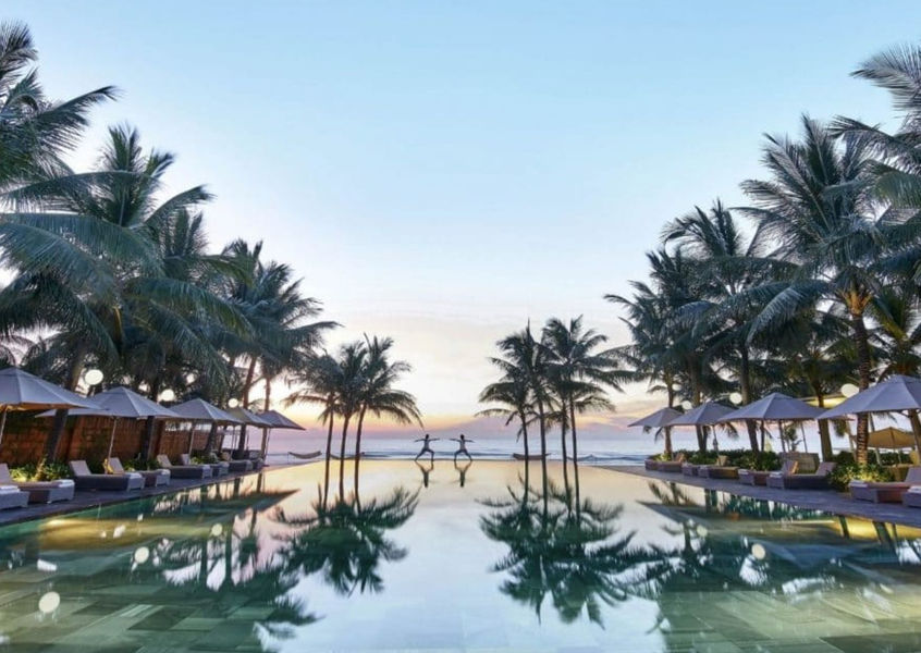 Sunset yoga session at TIA Wellness Resort infinity pool between coconut palms