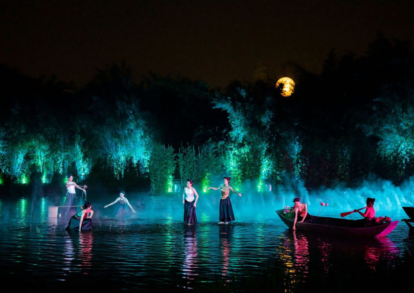 Dancers performing on lake surface under full moon at night show Vietnam