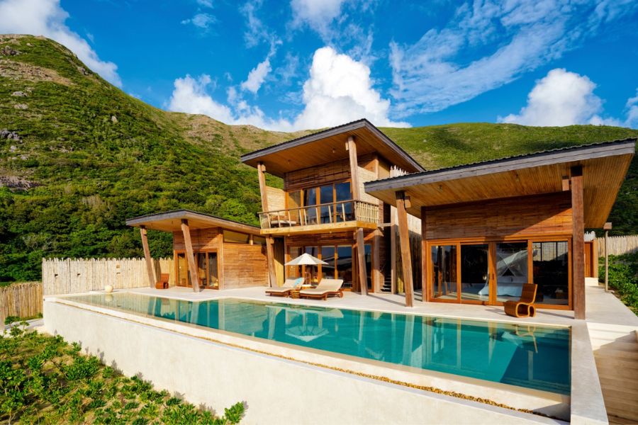 Wooden pool villa with forested mountain backdrop