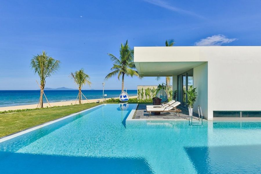 Modern white villa with infinity pool facing the beach