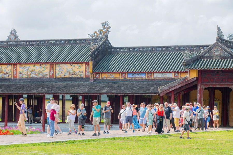 Tourists walking through Hue Imperial Citadel courtyard