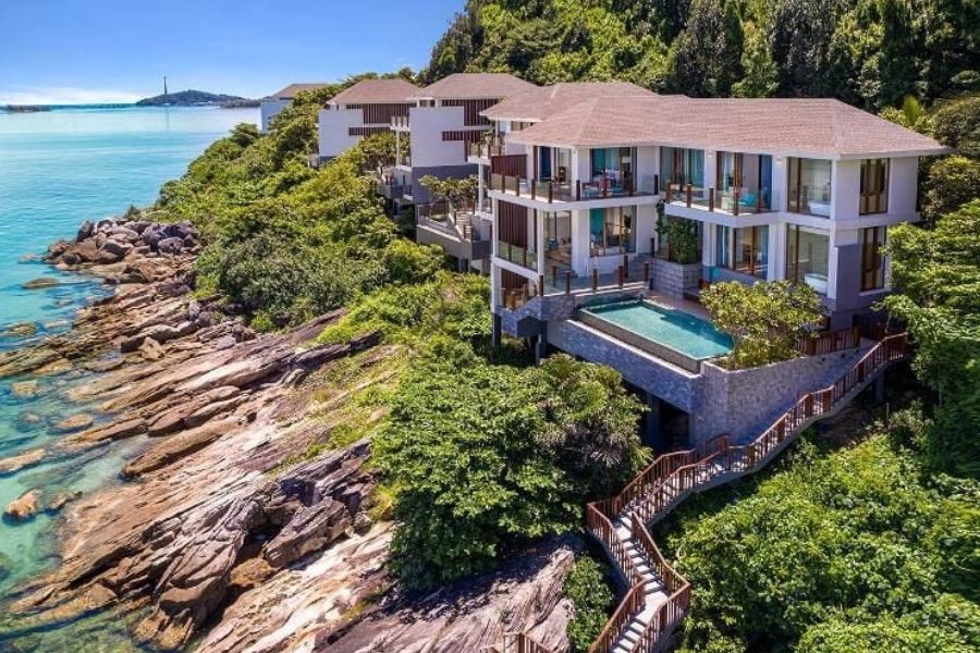 Cliffside pool villa overlooking rocky coastline and sea