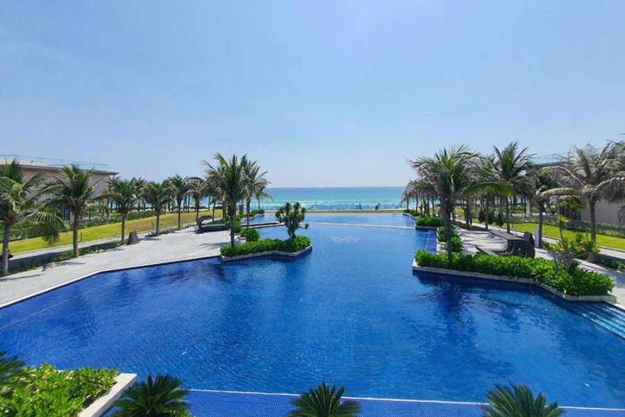 Large resort pool with palm trees and ocean view
