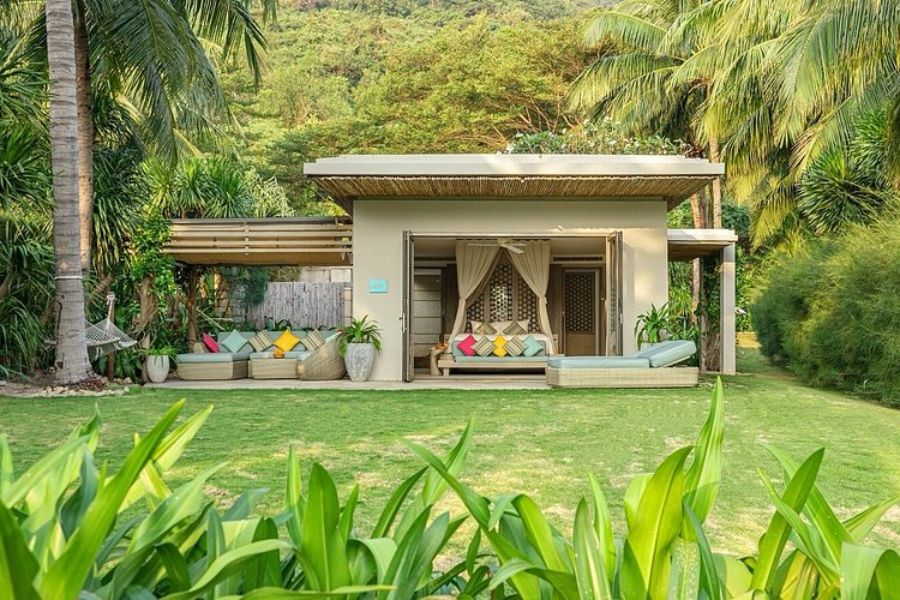 Garden villa exterior with an open-air lounge area surrounded by tropical greenery at an eco resort
