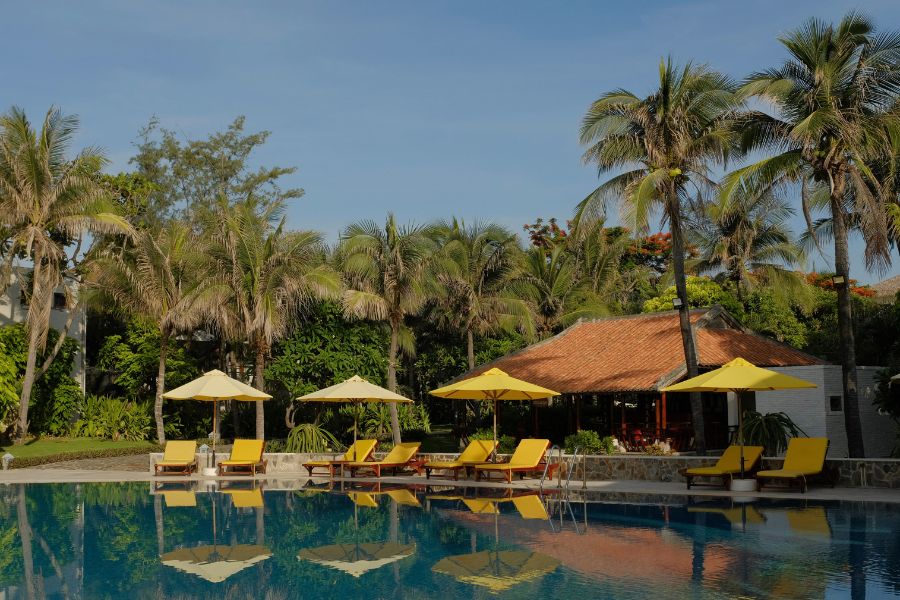 Luxury Vietnam DMC resort pool with yellow loungers and palm garden