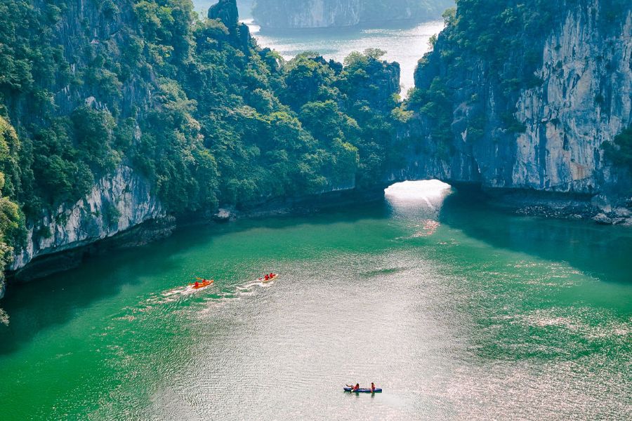 Kayaking emerald water limestone cliffs Halong Bay
